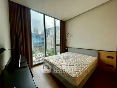 Modern bedroom with large window offering stunning city views in high-rise apartment.