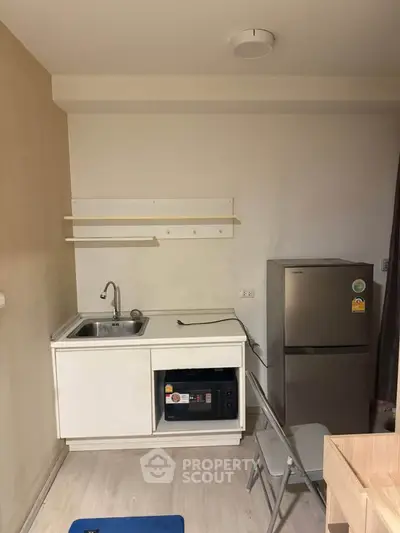 Compact kitchen with fridge and sink in modern apartment