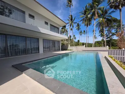 Luxurious modern villa with private pool and palm tree views, perfect for tropical living.
