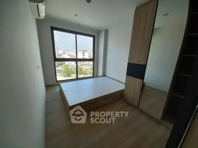Modern bedroom with large window and built-in wardrobe, offering a bright and spacious feel.