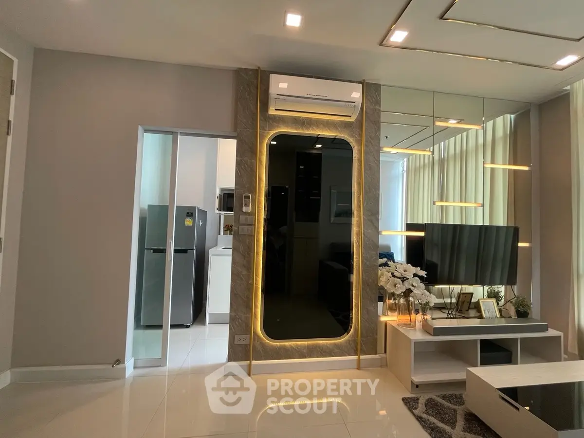 Modern living room with sleek design and stylish decor, featuring a wall-mounted TV and elegant lighting.