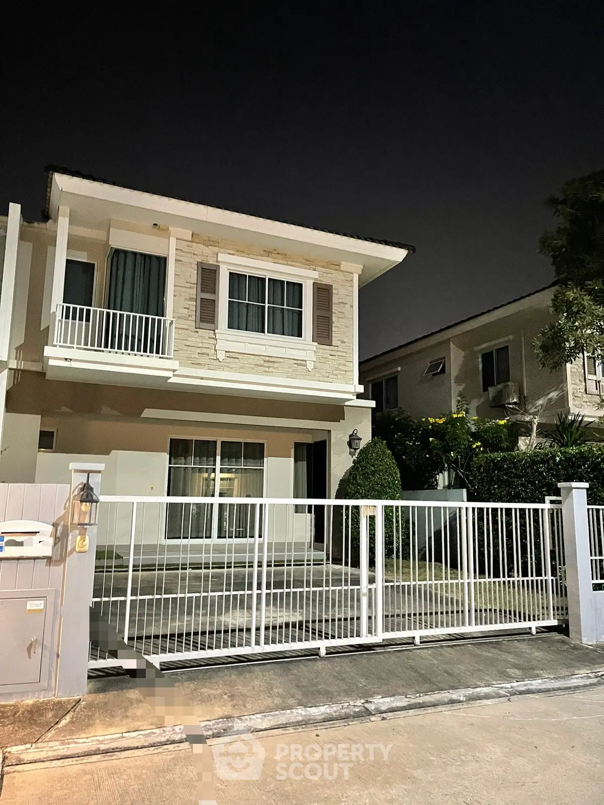 Charming two-story house with gated entrance and balcony, perfect for family living.