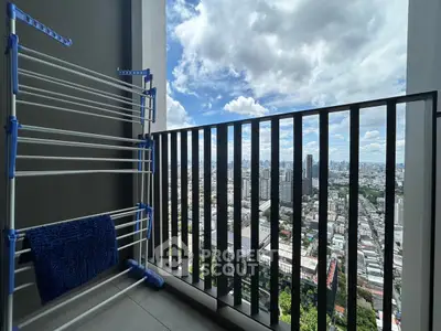 Stunning cityscape view from a high-rise balcony with drying rack.