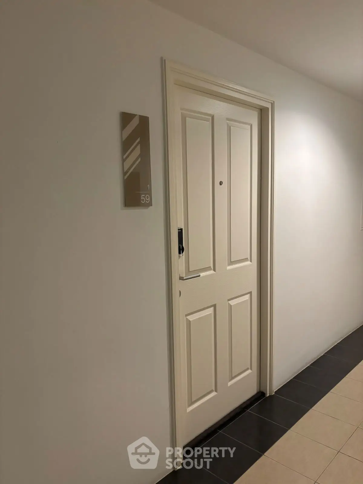 Modern apartment entrance with sleek white door and minimalistic design.
