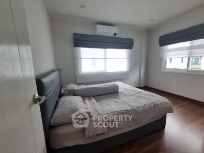 Spacious bedroom with modern decor and large windows for natural light