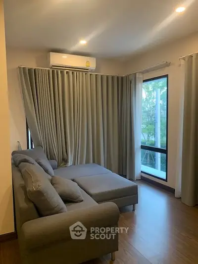 Cozy living room with modern gray sofa and large windows for natural light