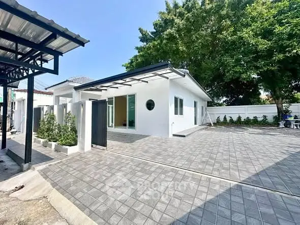 Modern single-story house with spacious driveway and lush greenery