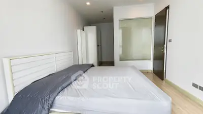Spacious modern bedroom with minimalist design and ample natural light.