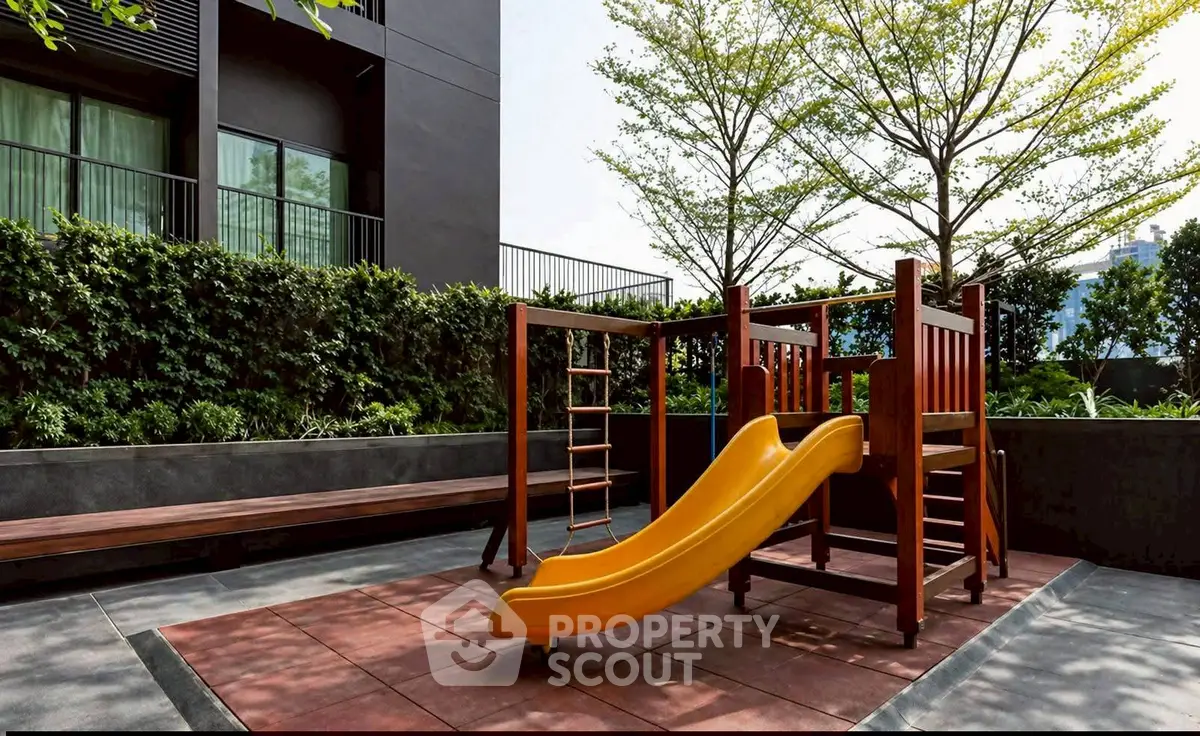 Modern apartment building with outdoor playground and lush greenery.