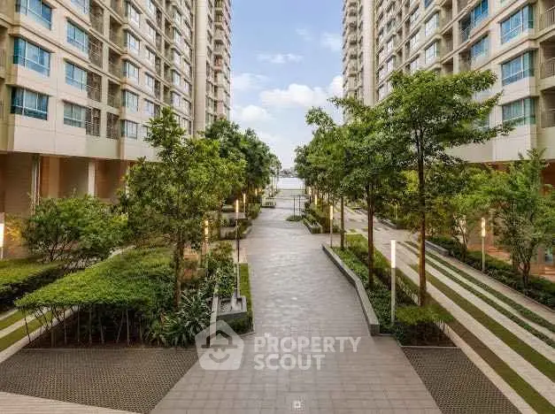 Modern apartment complex with lush greenery and spacious walkway