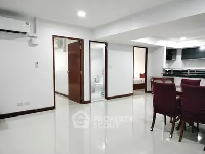 Spacious open-plan living area with modern kitchen and dining space in a stylish apartment.
