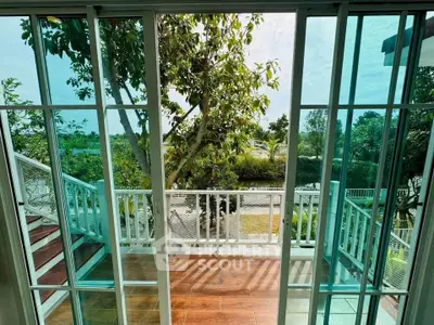 Stunning balcony view with lush greenery and elegant glass doors.