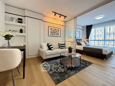 Modern open-plan living room and bedroom with stylish decor and natural light