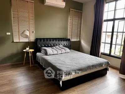 Modern bedroom with stylish decor and large windows for natural light