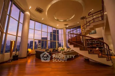 Luxurious penthouse living room with panoramic city views and elegant spiral staircase.