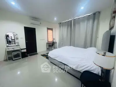 Spacious modern bedroom with elegant decor and ample natural light.