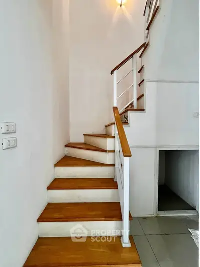 Elegant wooden staircase with modern railing in a bright interior space