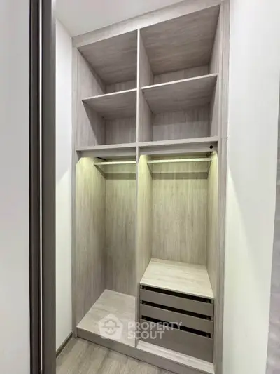Spacious walk-in closet with modern wooden shelving and ample storage space.