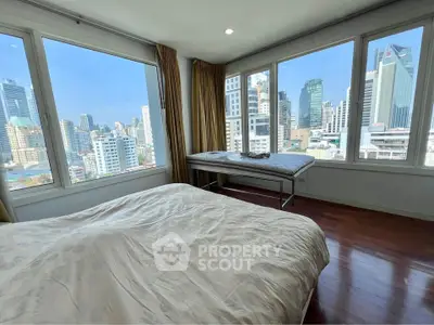 Spacious bedroom with stunning city skyline view and large windows