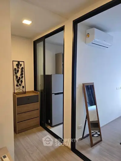 Modern apartment interior with sleek design, featuring a compact kitchen area and stylish decor.