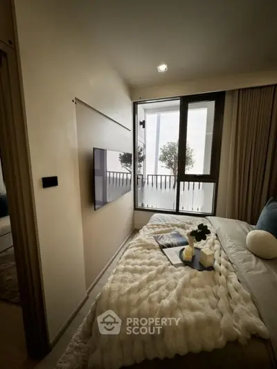Cozy bedroom with modern decor and balcony view, perfect for relaxation.