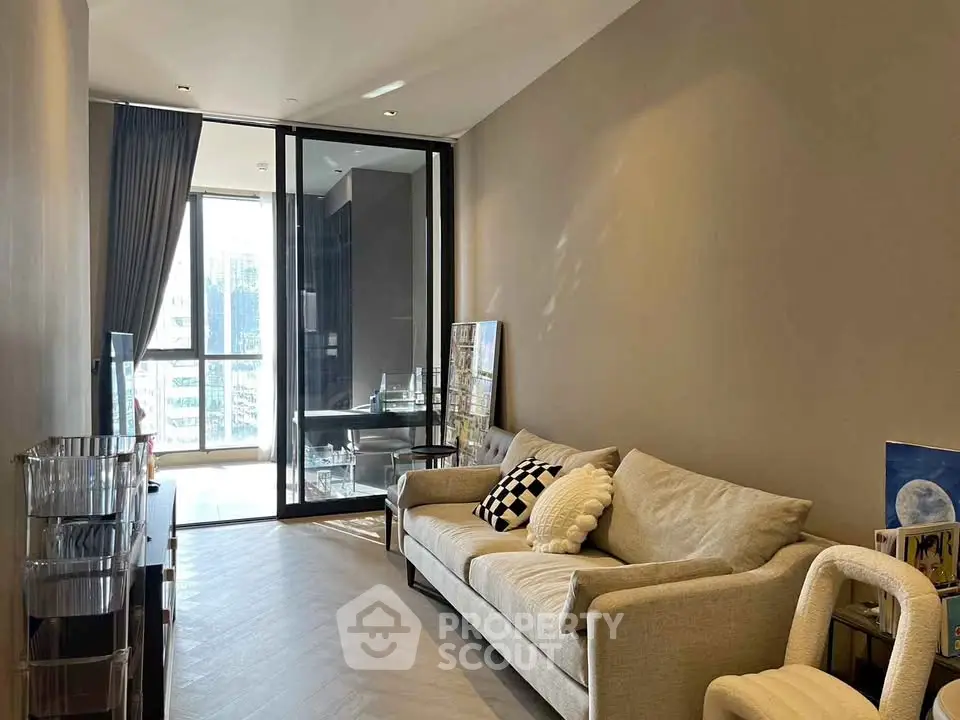 Modern living room with cozy sofa and large window offering natural light in a stylish apartment.