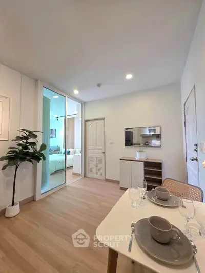 Modern living room with dining area and view into bedroom, featuring stylish decor and natural light.