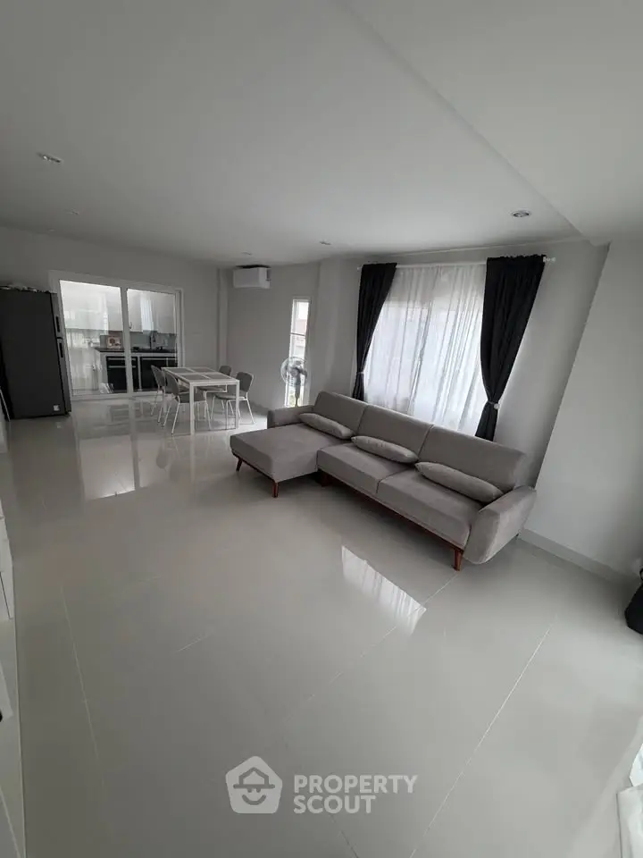 Spacious modern living room with sleek furniture and large windows for natural light.