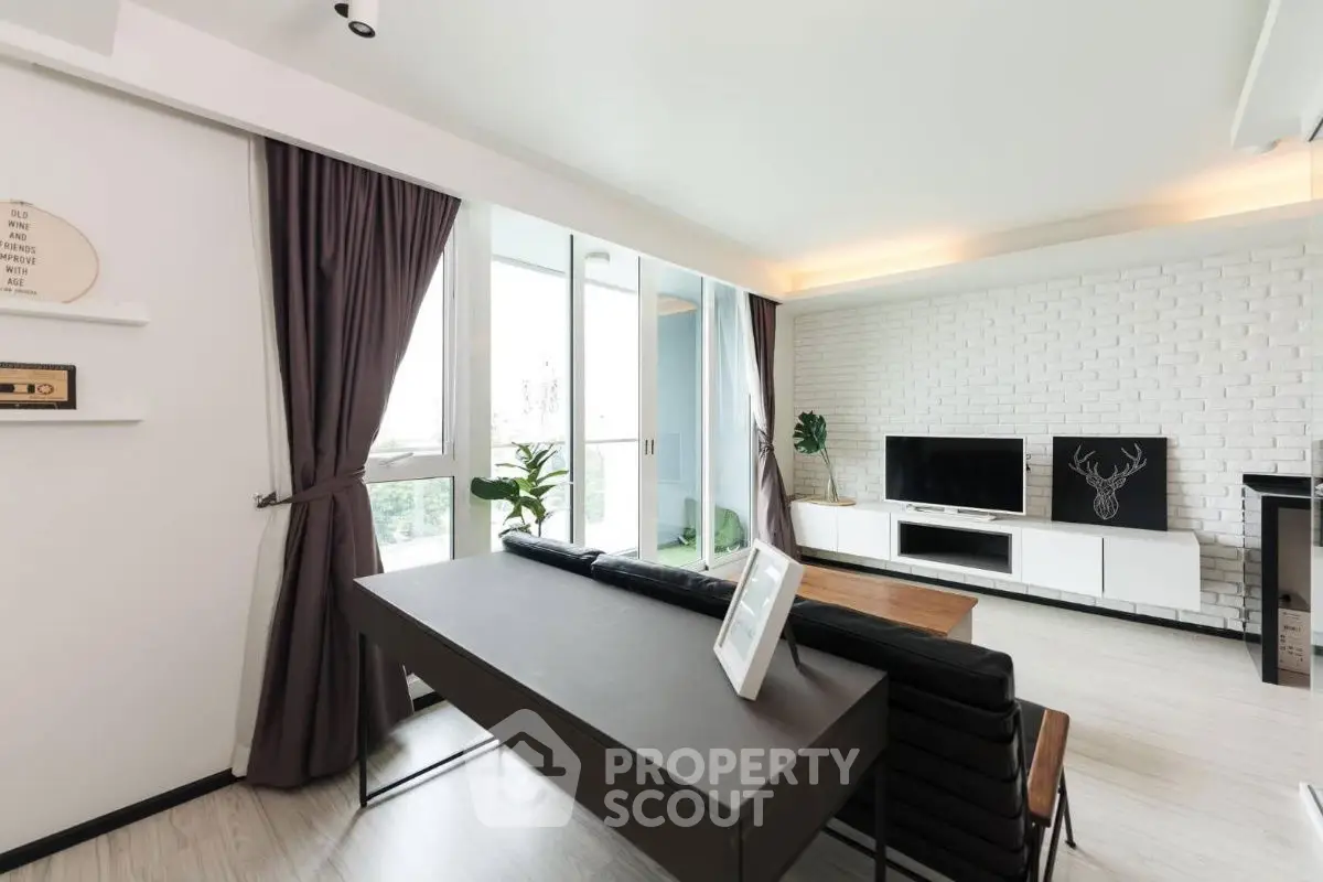 Modern living room with sleek furniture and large windows in a stylish apartment.