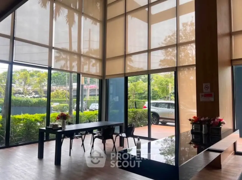 Spacious modern lobby with large windows and garden view, ideal for welcoming guests.