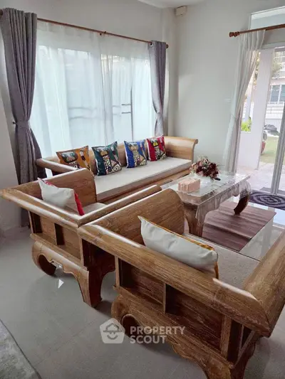 Elegant living room with stylish wooden furniture and colorful cushions, perfect for modern home decor.