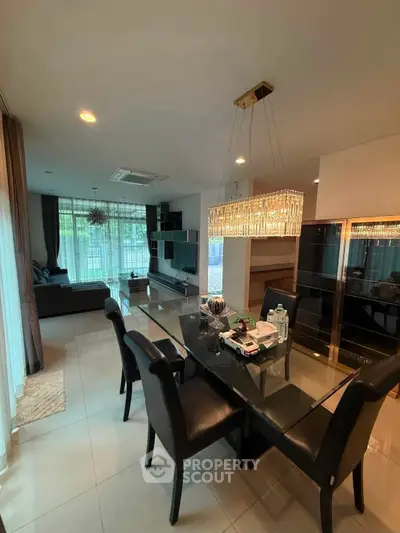Luxurious dining and living area with elegant chandelier and modern furnishings