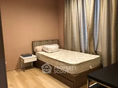 Cozy bedroom with single bed and elegant curtains, perfect for a peaceful retreat.