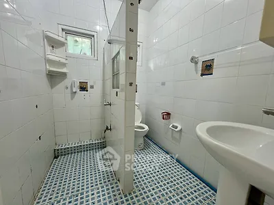 Spacious bathroom with modern fixtures and tiled flooring in a bright, airy setting.