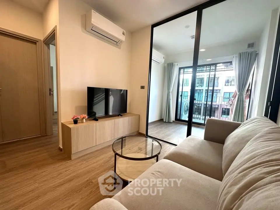 Modern living room with balcony view and sleek furniture in a stylish apartment.