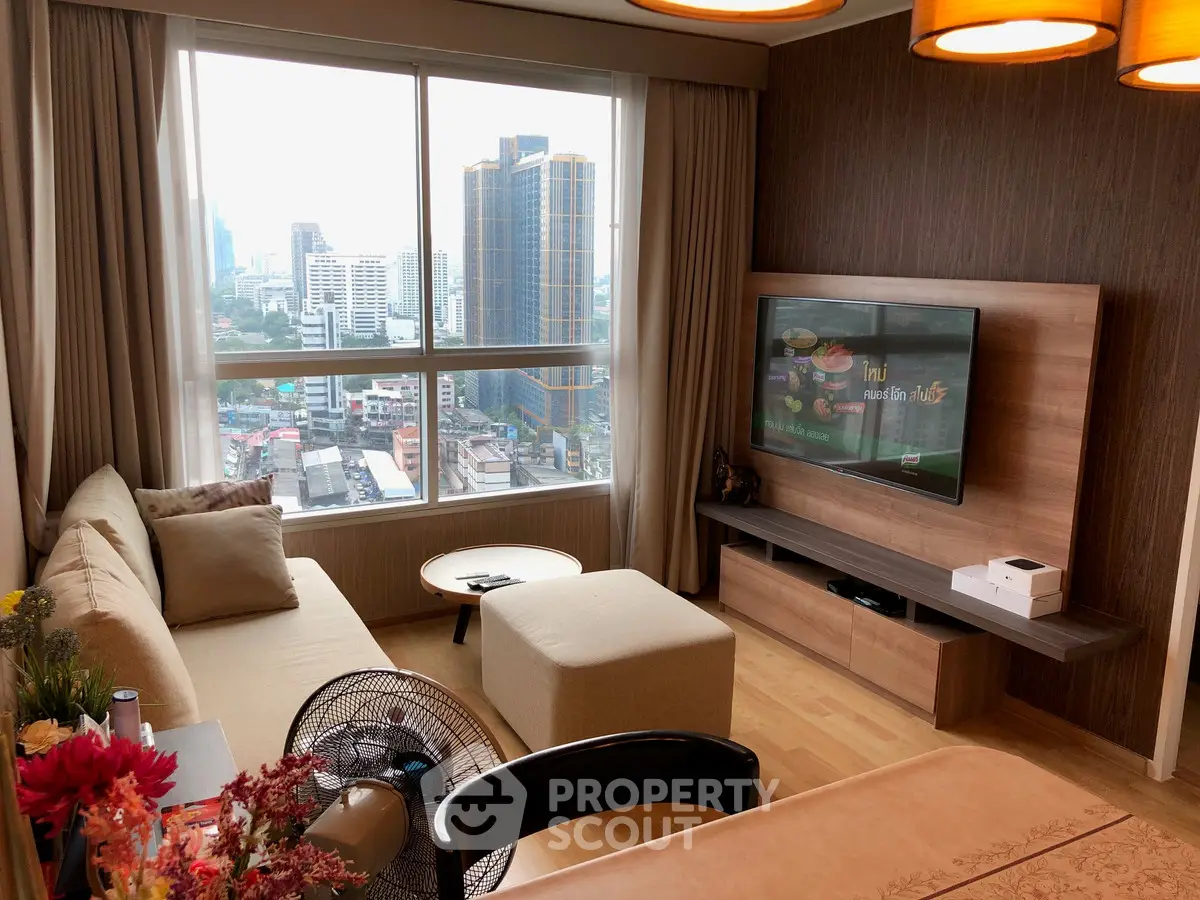 Modern living room with city view, stylish furniture, and large window in urban apartment.