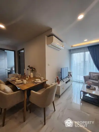 Modern living room with dining area and natural light, featuring elegant decor and cozy ambiance.