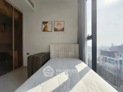 Modern bedroom with large window and city view, featuring minimalist decor and natural light.