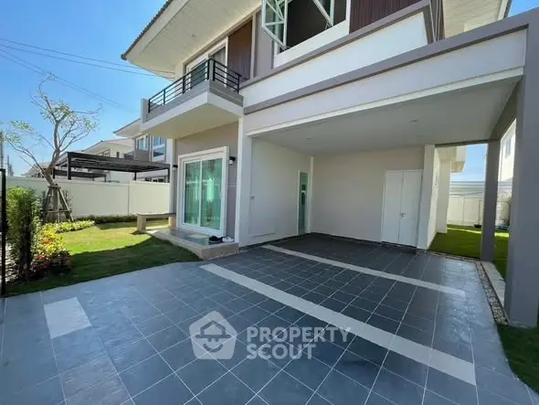Modern two-story house with spacious driveway and lush garden.