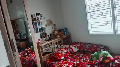 Cozy bedroom with vibrant decor and ample natural light from large window.