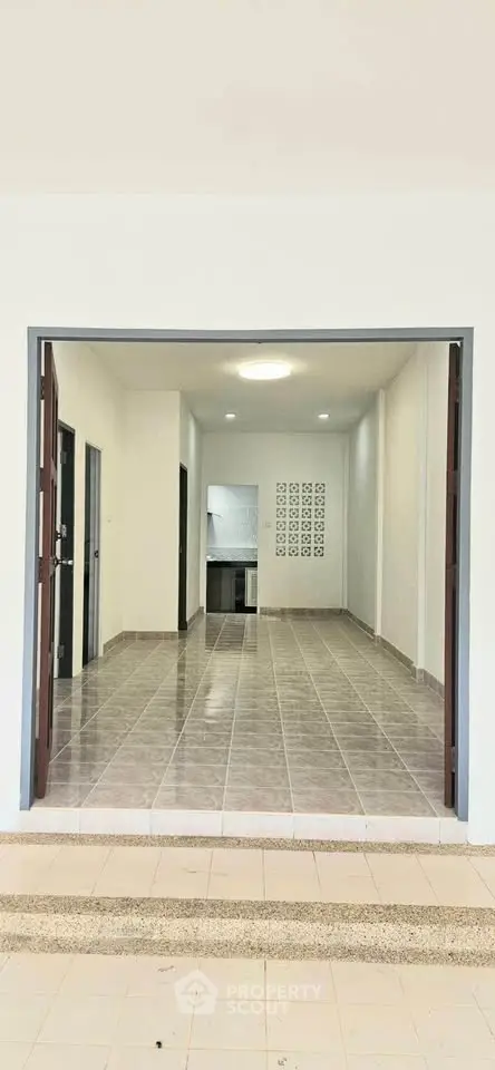 Spacious open-plan living area with tiled flooring and modern kitchen in a contemporary home.