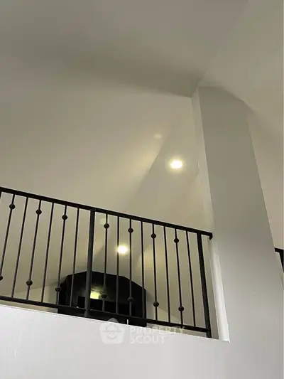 Modern interior with sleek black railing and recessed lighting