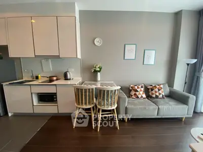 Modern open-layout kitchen and living room with stylish decor and cozy seating area.