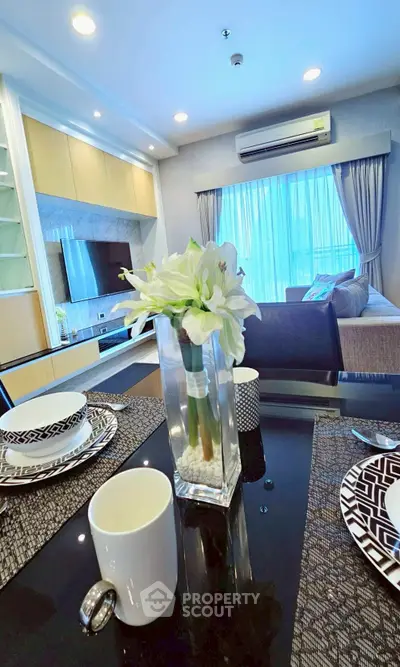 Modern living room with elegant decor and dining area, featuring a cozy sofa and large window with natural light.