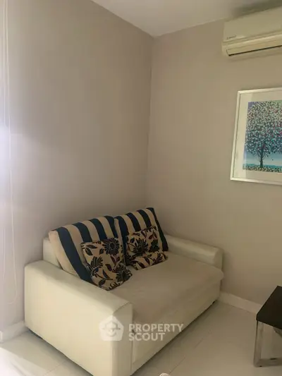 Cozy living room corner with a stylish sofa and modern wall art.