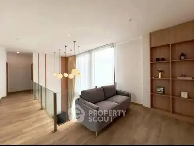 Modern living area with stylish sofa and elegant lighting in a bright, open space.