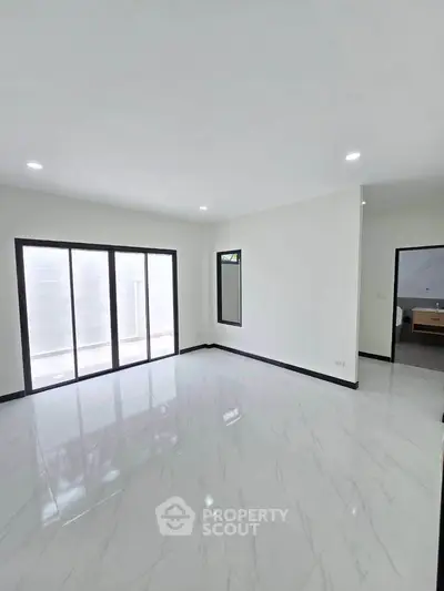 Spacious empty room with large windows and glossy white flooring
