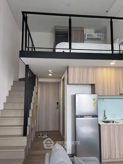 Modern loft apartment with mezzanine bedroom and sleek kitchen design.