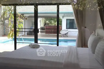 Luxurious bedroom with pool view in modern villa, perfect for relaxation and comfort.