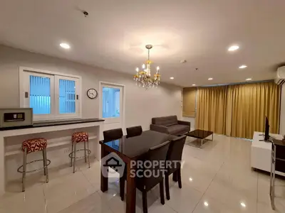 Spacious modern living room with elegant chandelier and open kitchen layout